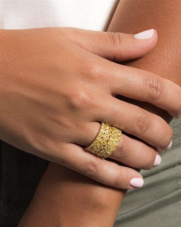 A woman's hand gracefully presents a gold eternity ring, symbolizing elegance and suitability for all occasions.