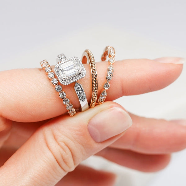 A woman's hand showcases three distinct diamond rings, symbolizing the blend of tradition and modern elegance in wedding sets.